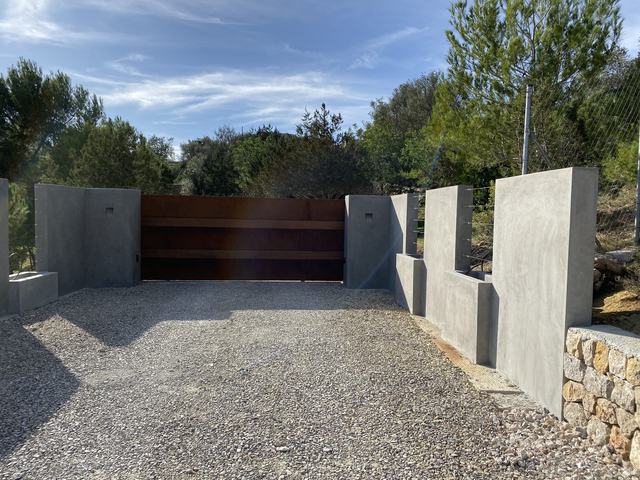 Puerta corredera de acero corten a la entrada de una finca