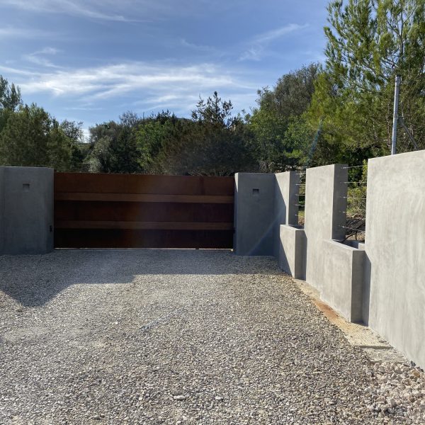 Puerta corredera de acero corten a la entrada de una finca