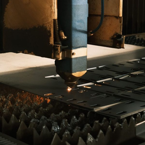 Cabezal de una máquina de corte por láser cortando piezas en una chapa de acero